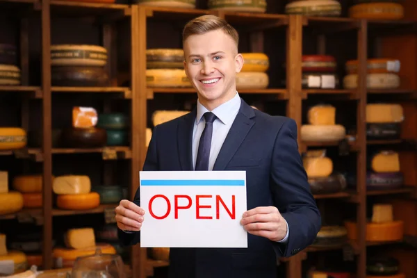 Business owner holding "OPEN" sign in his store — Stock Photo, Image