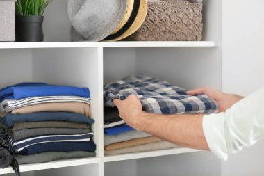 Adam malzeme çekme kıyafet dolabı üzerinden. 