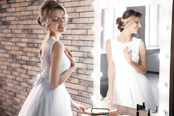 白の結婚式の美しい若い花嫁ドレス室内ミラーの近くのプロのアーティストによって作成された化粧品で — ストック写真