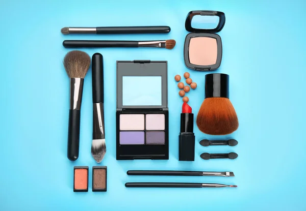 Cosmética decorativa y herramientas de maquillador profesional sobre fondo de color — Foto de Stock