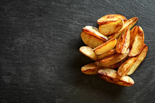 Savoureux quartiers de pommes de terre sur la table — Photo