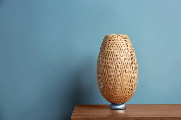 Elegantní lampa na stole u barevné stěny — Stock fotografie