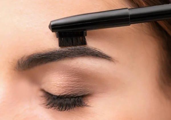 Mujer joven corrigiendo la forma de las cejas, primer plano —  Fotos de Stock