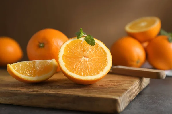 Placa de madeira com suculentas laranjas maduras na mesa — Fotografia de Stock