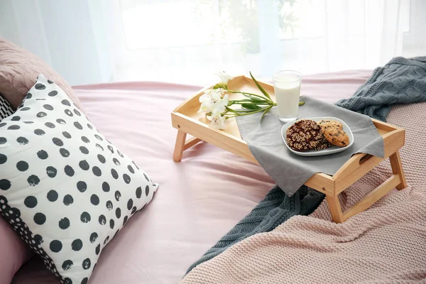 Bandeja con sabroso desayuno y flores en la cama — Foto de Stock