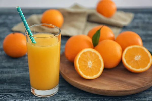 Verre avec jus d'orange frais et fruits sur table en bois — Photo