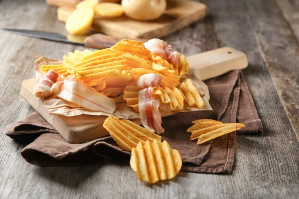 Patatas fritas crujientes con tocino en mesa de madera —  Fotos de Stock