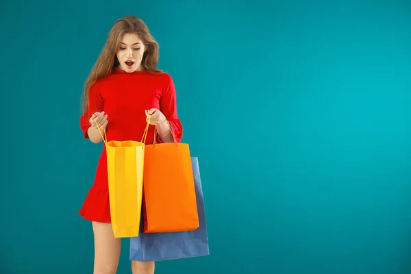 Mujer Joven Sorprendida Mirando Dentro Bolsa Compras Fondo Color — Foto de Stock