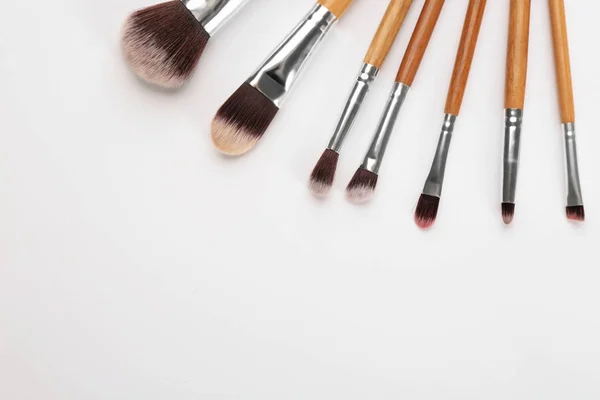 Diferentes pinceles de maquillador profesional sobre fondo blanco — Foto de Stock