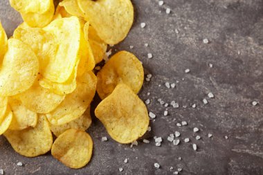 Gri masada tuz ile nefis gevrek patates cipsi