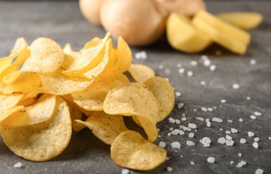 Gri masada tuz ile nefis gevrek patates cipsi