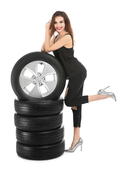 Молода жінка в спокусливому вбранні з автомобільними шинами на білому тлі — стокове фото