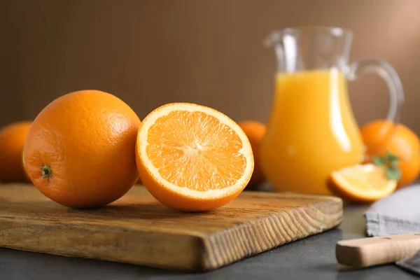 Träskiva med saftigt mogna apelsiner på bord — Stockfoto