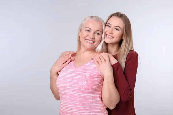 Молодая дочь и мать на цветном фоне — стоковое фото