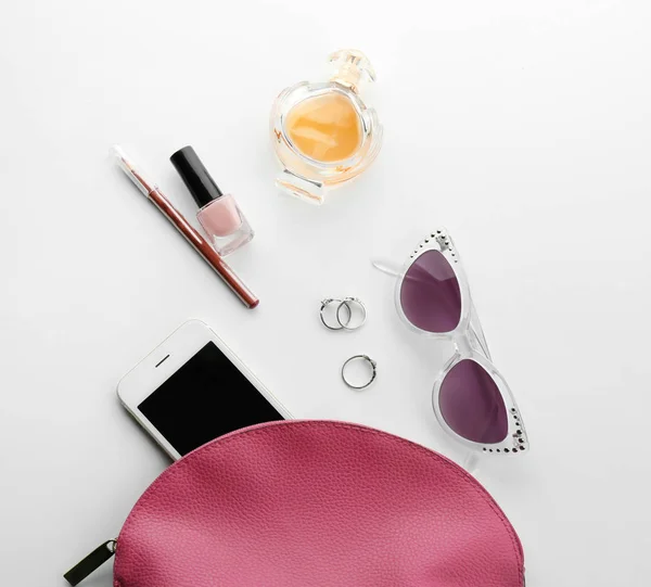 Garrafa de perfume, smartphone e produtos cosméticos em fundo branco — Fotografia de Stock
