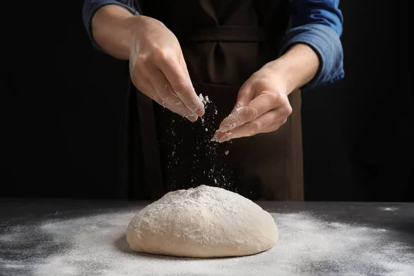 Donna cospargere la farina sopra la pasta fresca sul tavolo — Foto Stock