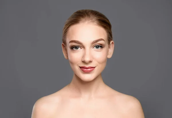 Retrato de una hermosa joven con la piel clara sobre fondo gris — Foto de Stock