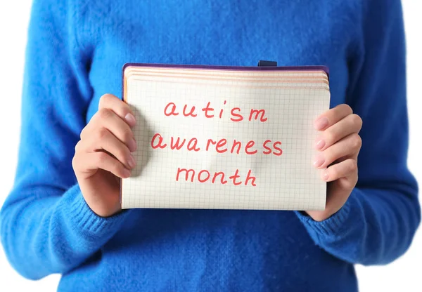 Kobieta trzyma notebook z frazą "Autism awareness month", zbliżenie — Zdjęcie stockowe