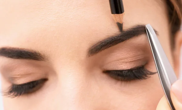 Mujer joven corrigiendo la forma de las cejas, primer plano —  Fotos de Stock