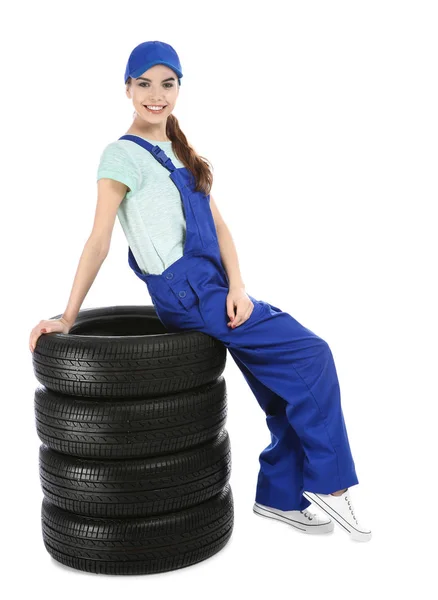 Unga mekaniker i uniform med bildäck på vit bakgrund — Stockfoto
