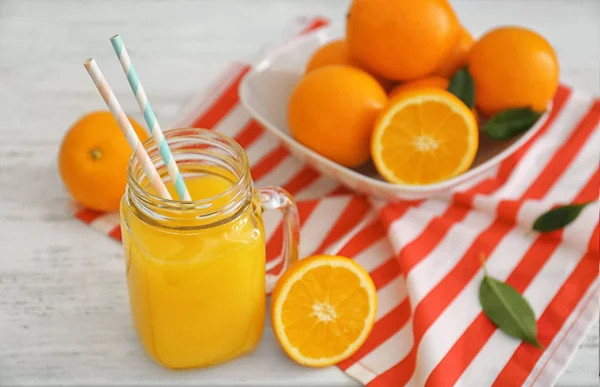 Pot Mason avec jus d'orange frais et fruits sur table en bois — Photo