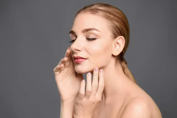 Portrait de belle jeune femme à la peau claire sur fond gris — Photo