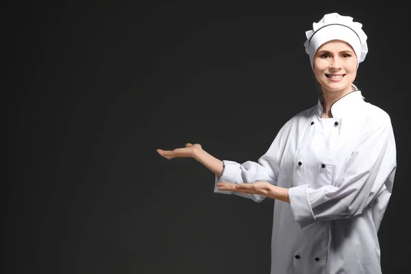 Chef femenino en uniforme sobre fondo negro — Foto de Stock