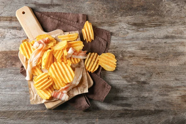 Patatas fritas crujientes con tocino en la mesa de madera, vista superior —  Fotos de Stock