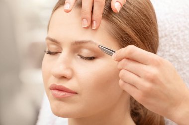 Kaş düzeltme prosedüründen geçen genç bir kadın, yakın plan.