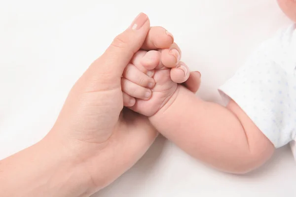 Mother holding newborn baby's hand on white background, closeup — Stock Photo, Image