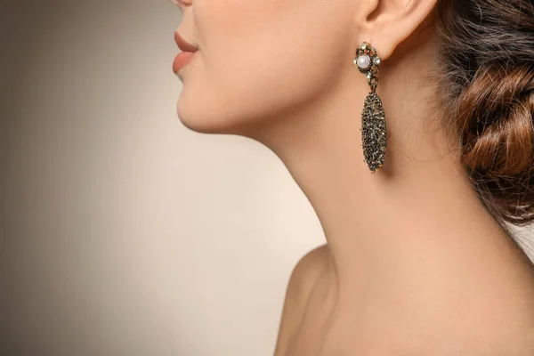 Mulher bonita com jóias elegantes no fundo de cor, close-up — Fotografia de Stock
