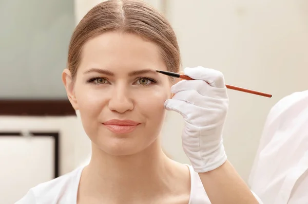 Mujer joven sometida a un procedimiento de corrección de cejas en el salón —  Fotos de Stock