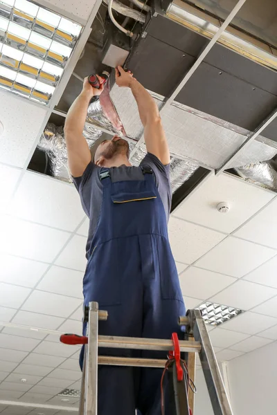 Technicien masculin réparer climatiseur industriel à l'intérieur — Photo