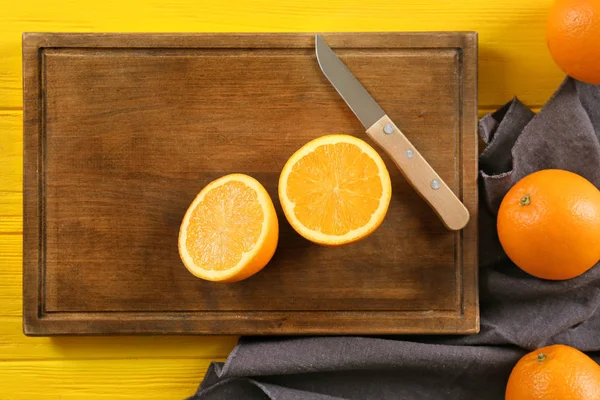 Tablero de madera y jugosas naranjas maduras en la mesa, vista superior —  Fotos de Stock