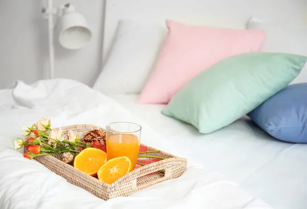 Dienblad met smakelijk ontbijt op comfortabele bed thuis — Stockfoto