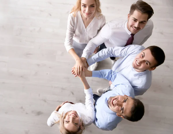 Jóvenes poniendo manos juntas — Foto de Stock