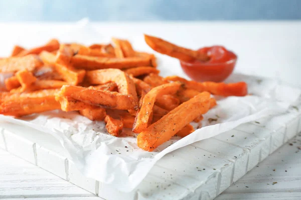 Board with tasty sweet potato fries — Stock Photo, Image