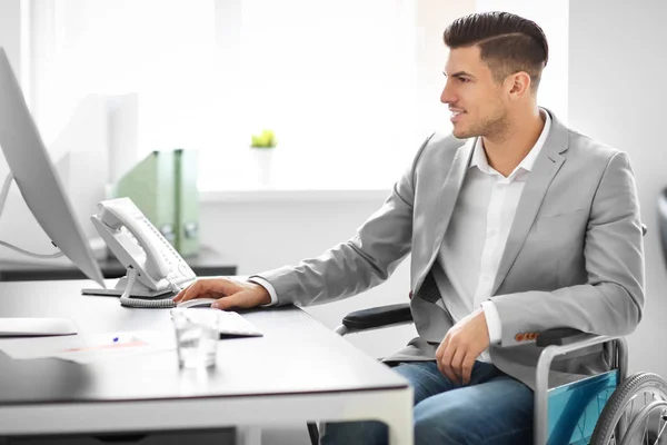 Jonge man in rolstoel op werkplek — Stockfoto