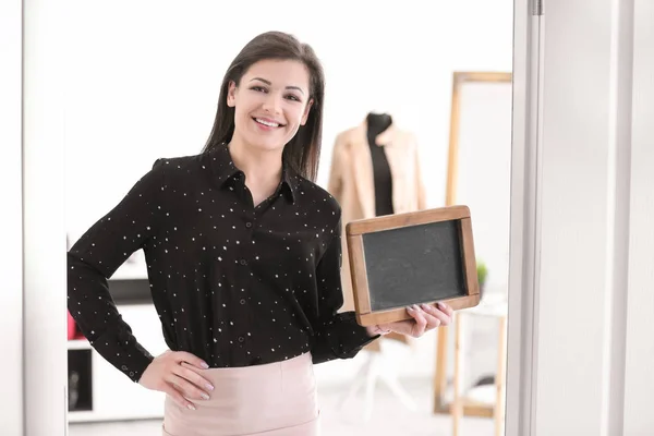 Retrato de mulher jovem com mini quadro em boutique. Proprietário das pequenas empresas — Fotografia de Stock