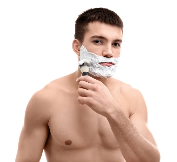 Hombre joven aplicando espuma de afeitar — Foto de Stock