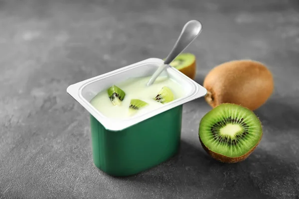 Plastic beker met lekker kiwi yoghurt op tafel — Stockfoto