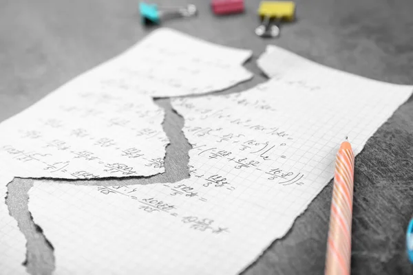 Hoja de papel rasgada con tarea en la mesa — Foto de Stock