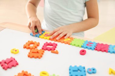 Kapalı ev ödevi yaparken rakamlar ile oynarken küçük kız