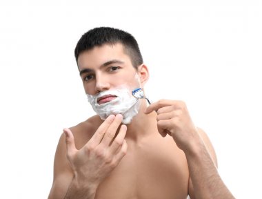 Yakışıklı genç adam tıraş oluyor.