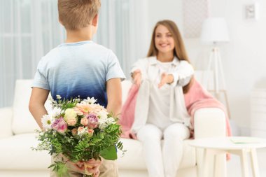 Sevimli küçük çocuk annesi evde arkasından için buket çiçek gizleme