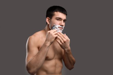 Yakışıklı genç adam tıraş oluyor.