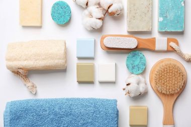 Beyaz arka plan üzerinde yumuşak havlu ve banyo aksesuarları ile düz yatıyordu kompozisyon