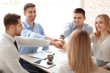 Gençler birlikte ellerini koyarak 