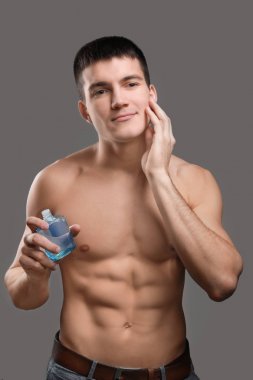 Tıraş losyonu gri arka plan uygulama yakışıklı genç