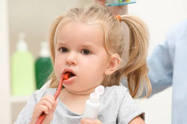 Petite fille brossant les dents dans la salle de bain — Photo